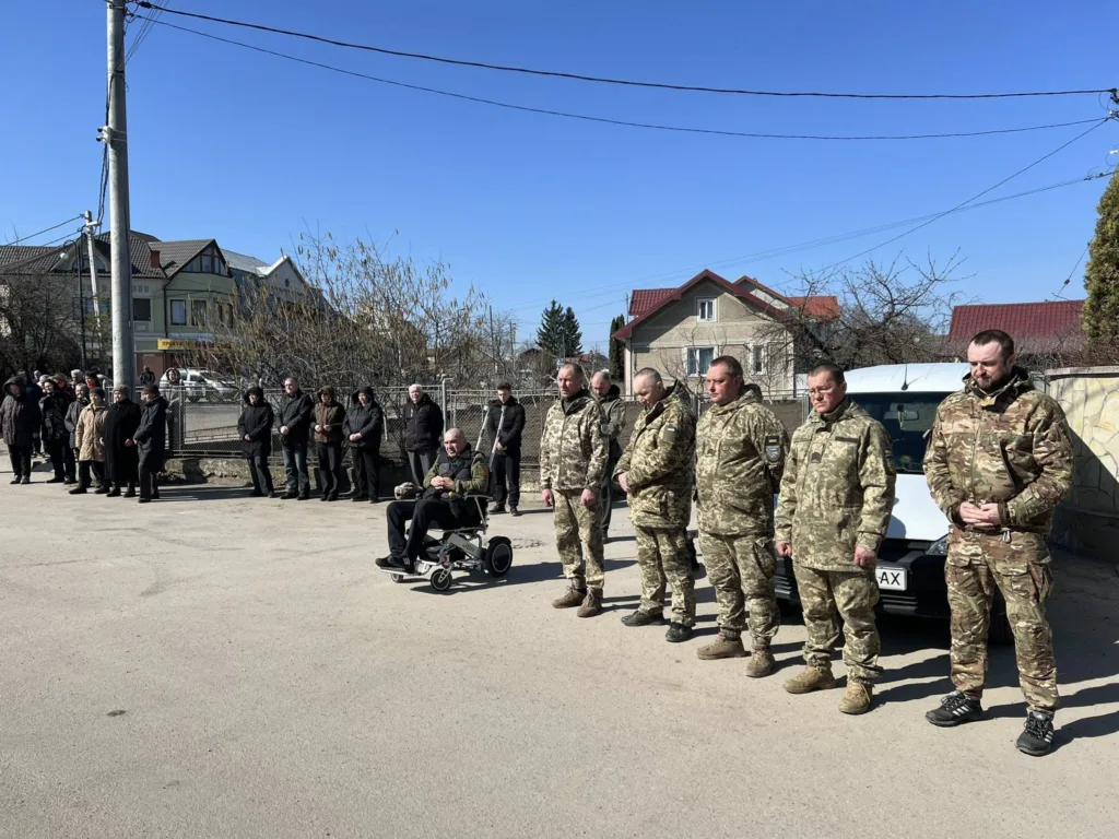Військові та люди стоять на вулиці під час церемонії
