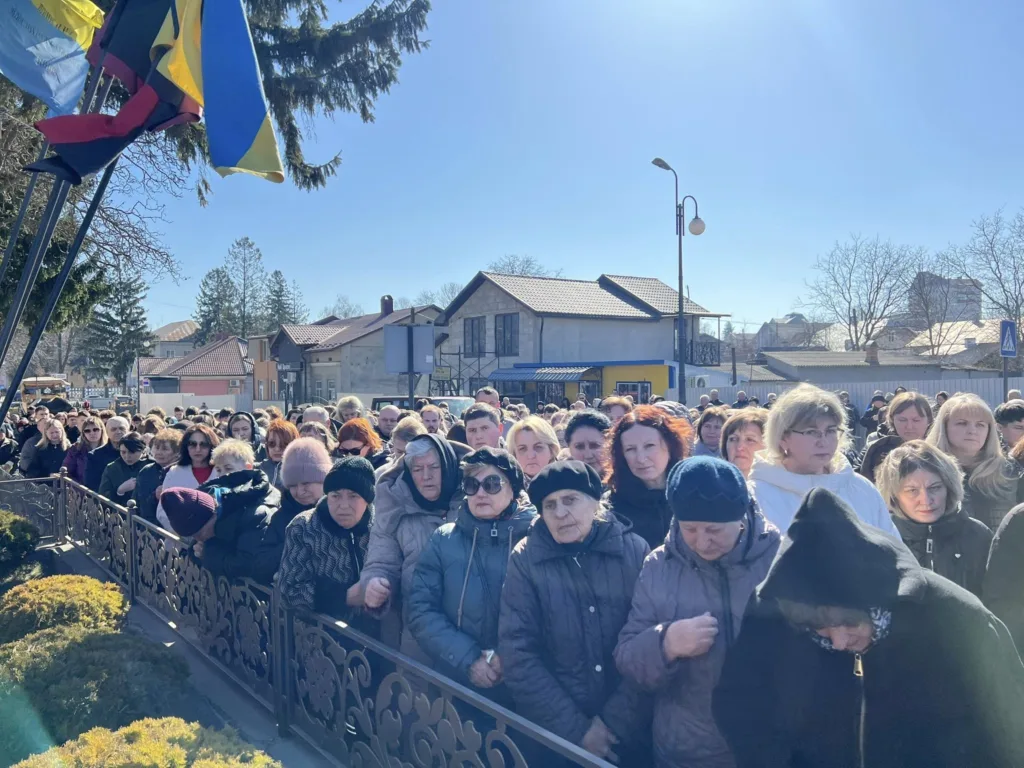 Люди зібралися на вулиці під прапорами України