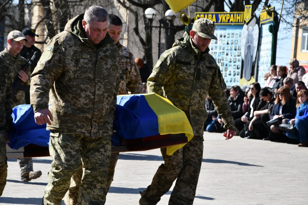 Військові несуть труну з українським прапором