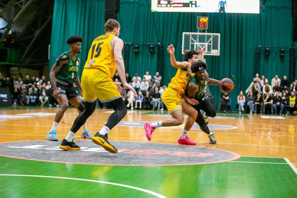 Баскетбольний матч між командами у жовтій та зеленій формі