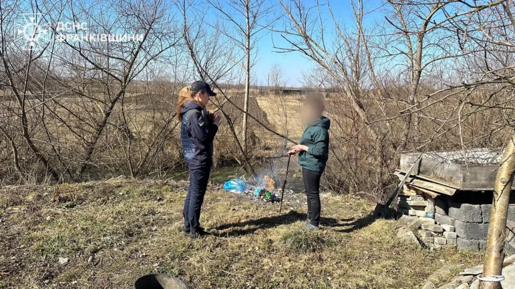Рятувальниця спілкується з людиною біля багаття на природі