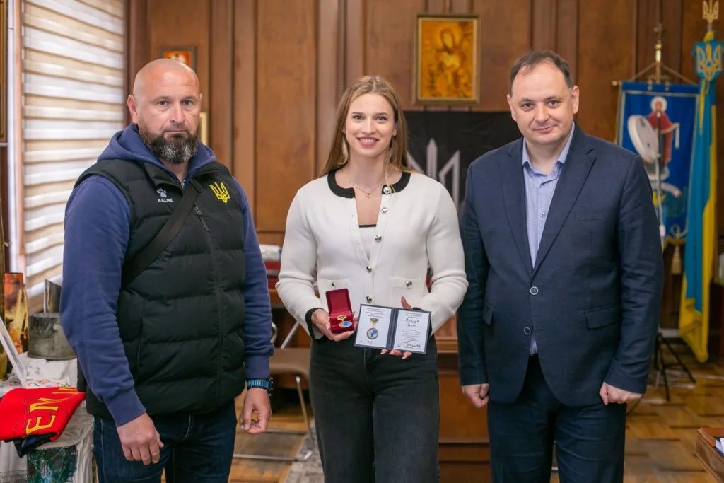 Жінка отримує нагороду від представників України