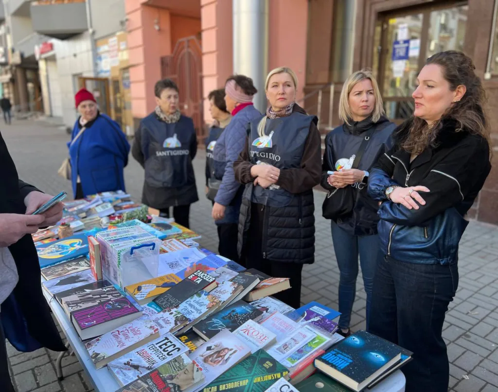 Волонтери біля столу з книжками на вулиці