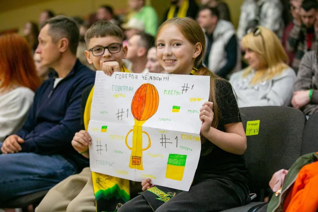 Діти з плакатом на спортивних змаганнях