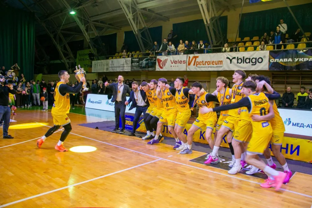 Баскетбольна команда святкує перемогу з кубком