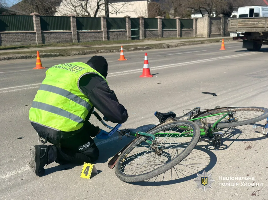 Поліцейський досліджує місце ДТП з велосипедом