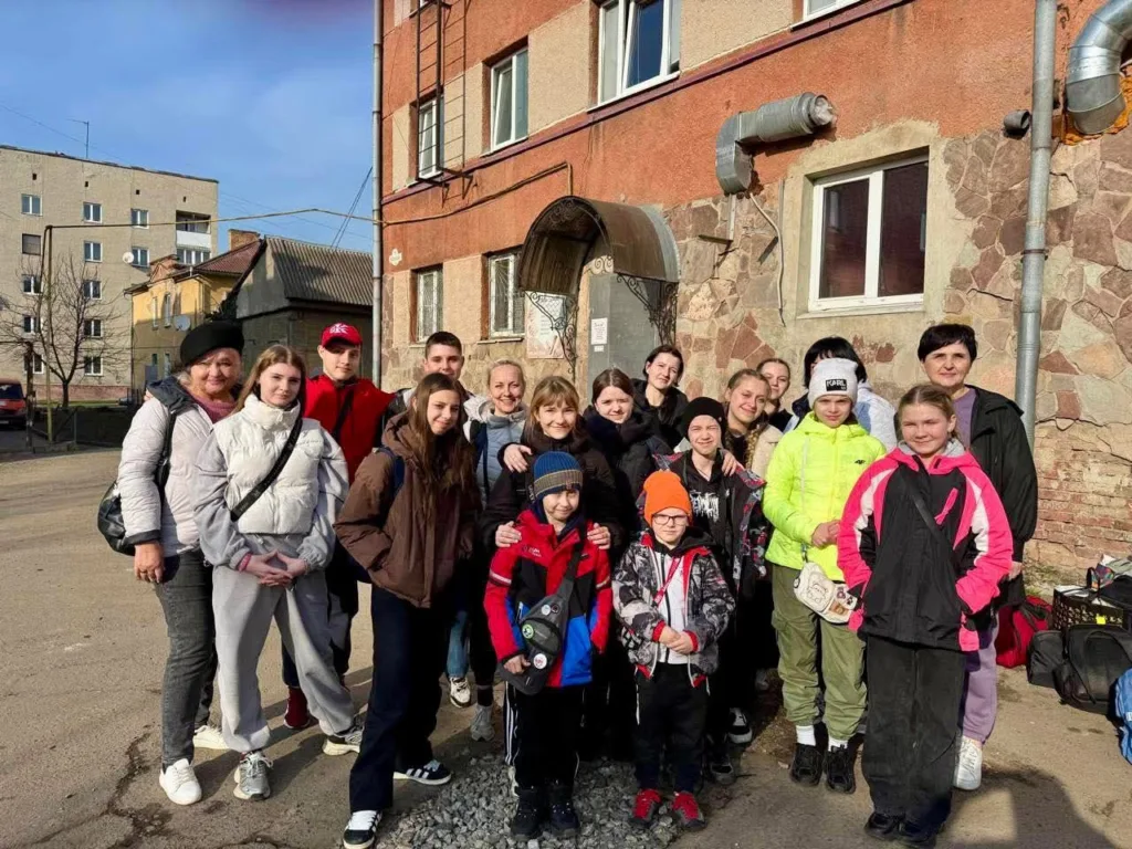 Група людей позує біля будівлі на вулиці