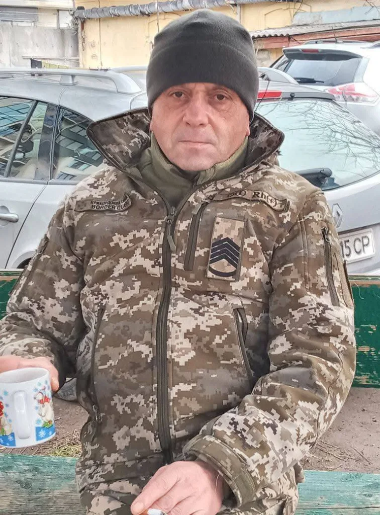 Військовий у камуфляжі тримає горнятко на вулиці