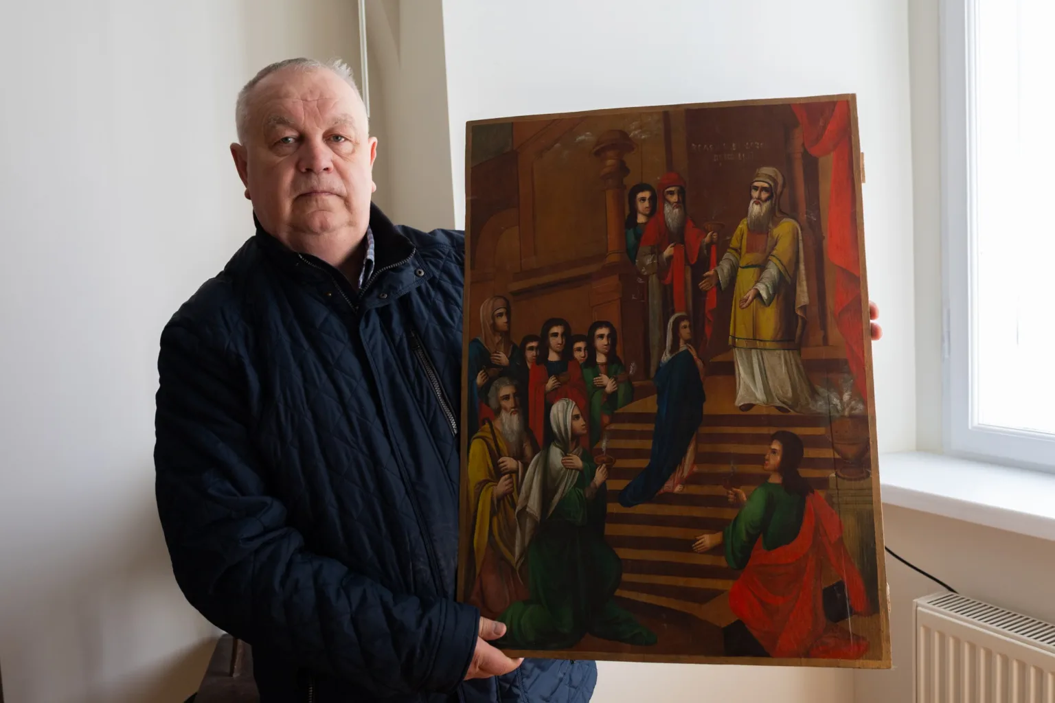 Чоловік тримає старовинну релігійну картину