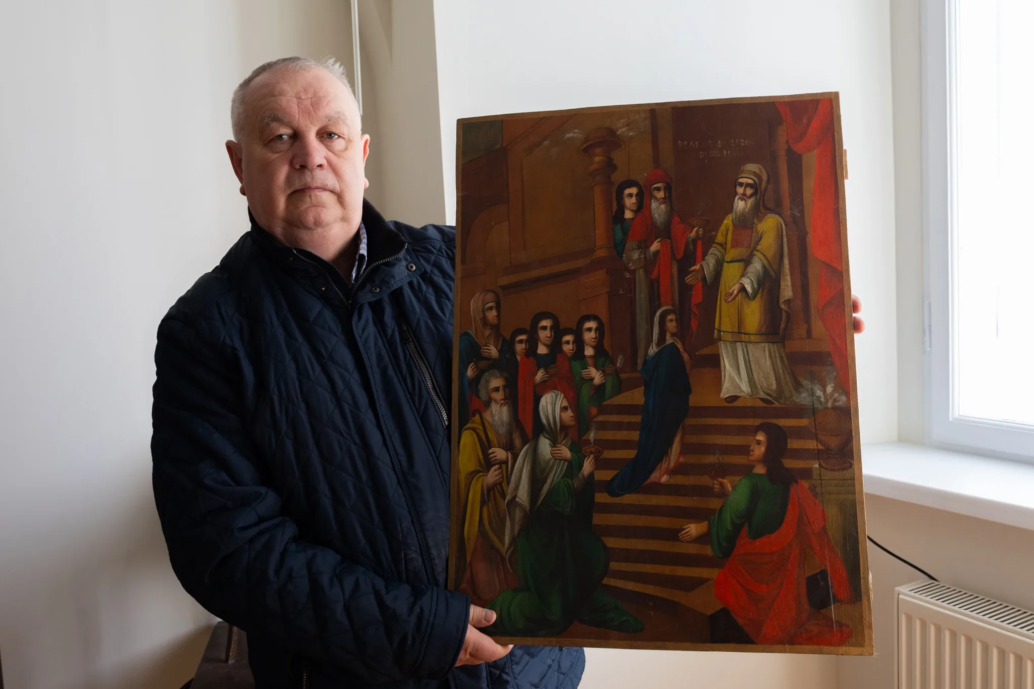 Чоловік тримає старовинну релігійну картину