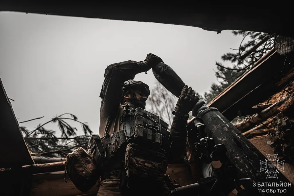 Військовий заряджає міномет у польових умовах