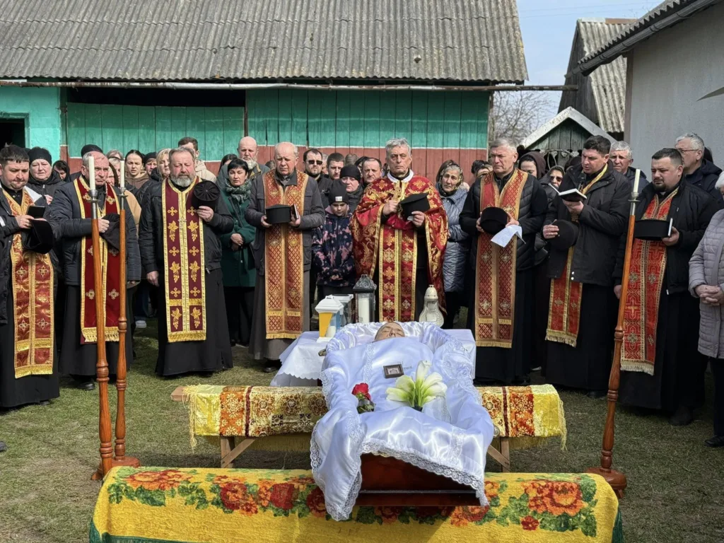 Священники проводять похоронну церемонію над померлим