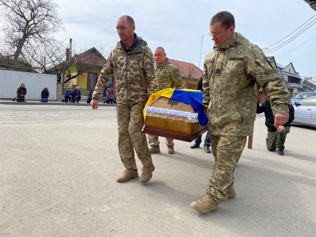 Військові несуть труну з українським прапором