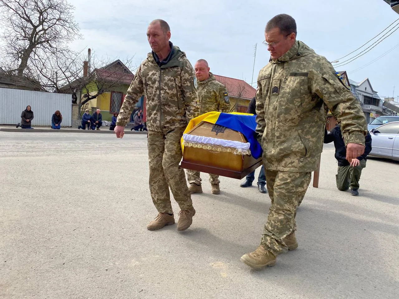 Військові несуть труну з українським прапором