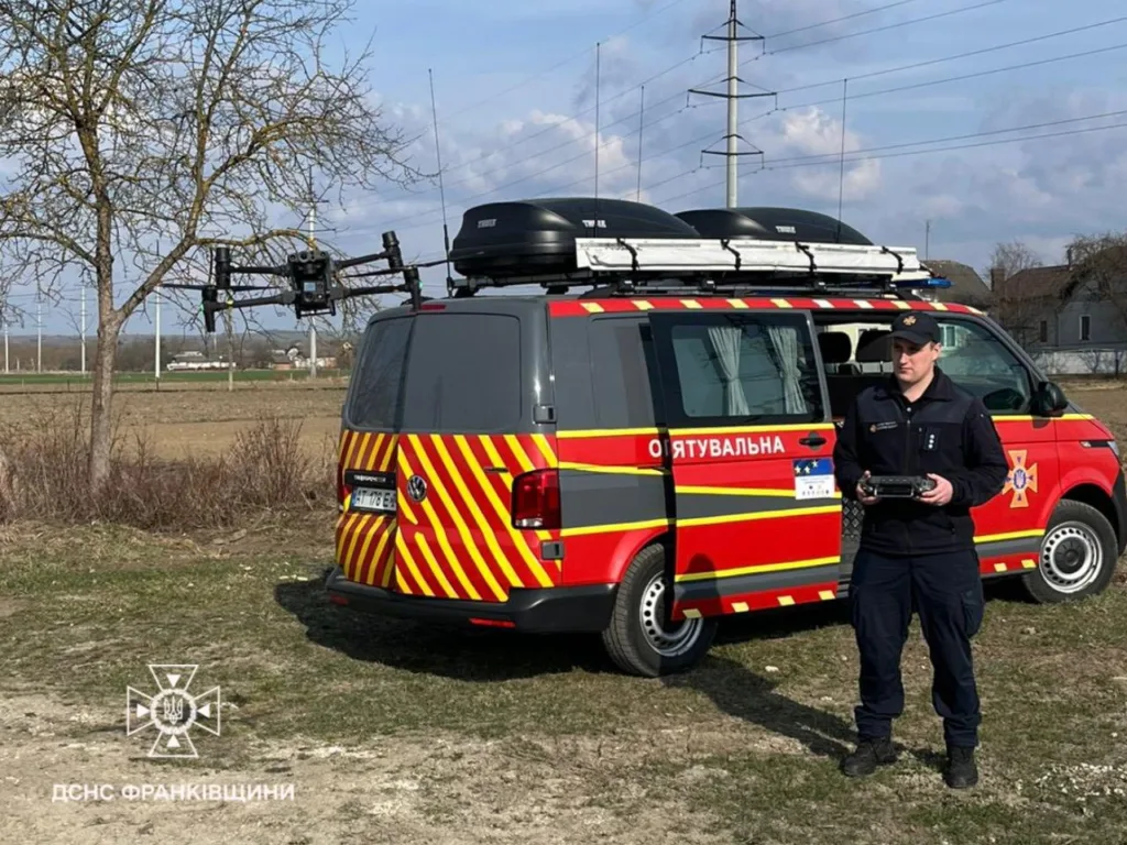 Рятувальник керує дроном біля пожежного автомобіля