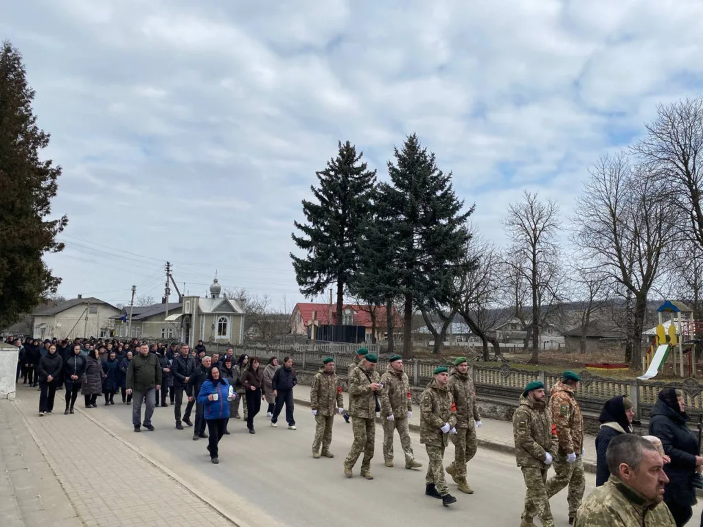Військові та люди йдуть вулицею українського міста