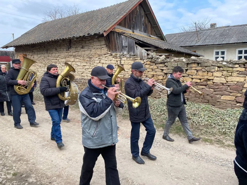 Музиканти грають на духових інструментах у селі