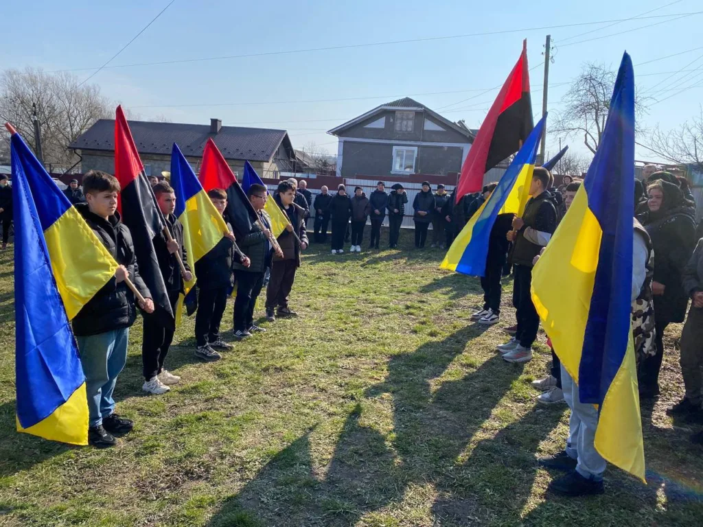 Люди тримають українські прапори на вуличній події