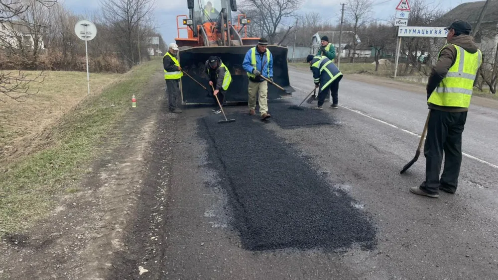 Робітники ремонтують асфальтовану дорогу