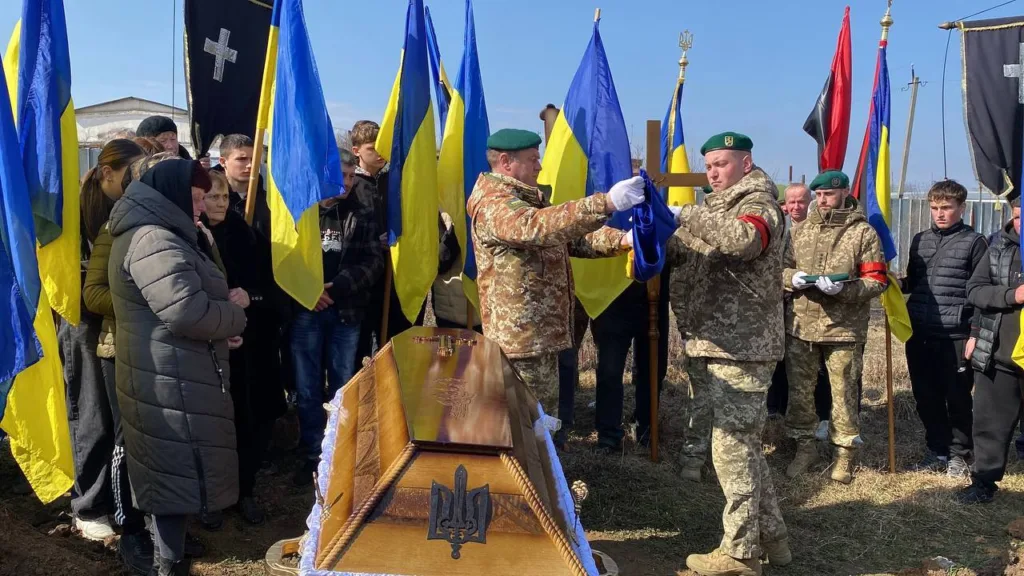 Похорон українського військового з державними прапорами