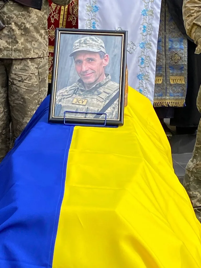 Портрет військового на труні з прапором України