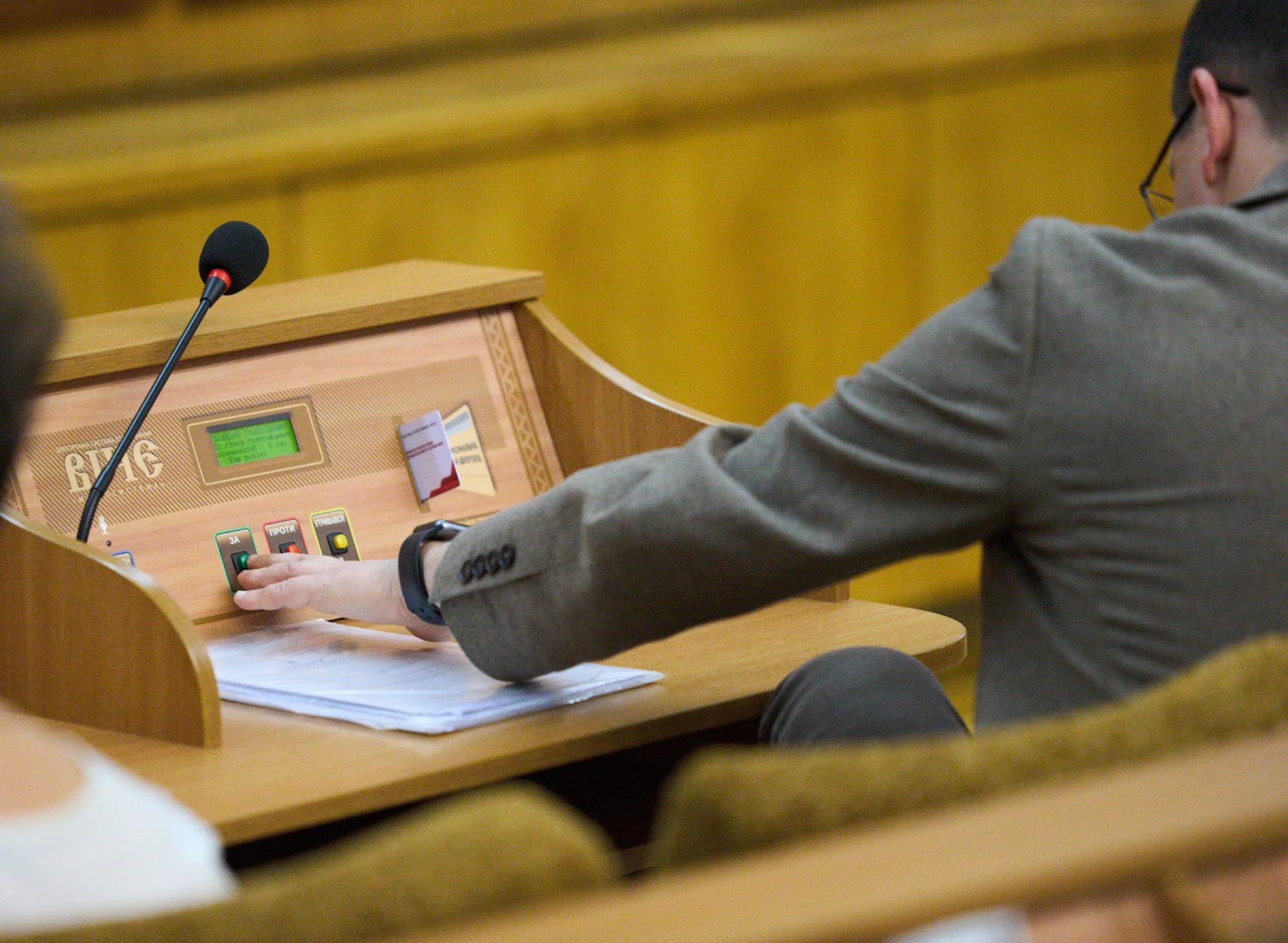 Депутат натискає кнопку для голосування у парламенті