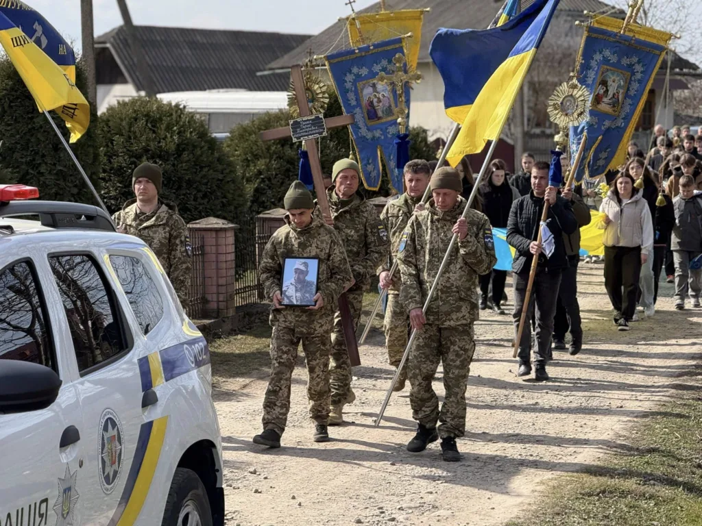 Військові несуть прапори України на похороні