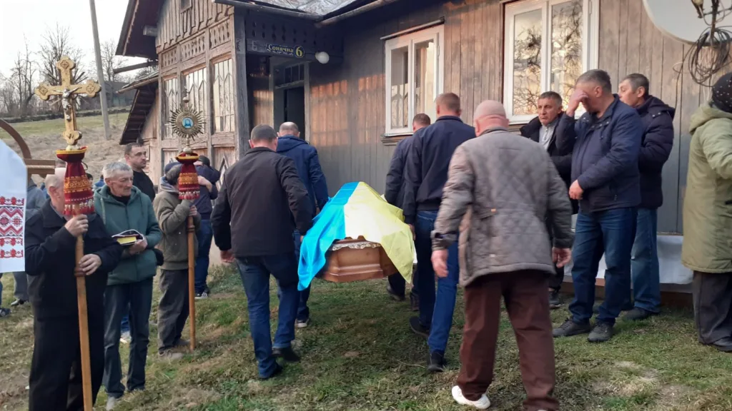 Похоронна процесія з труною під прапором України