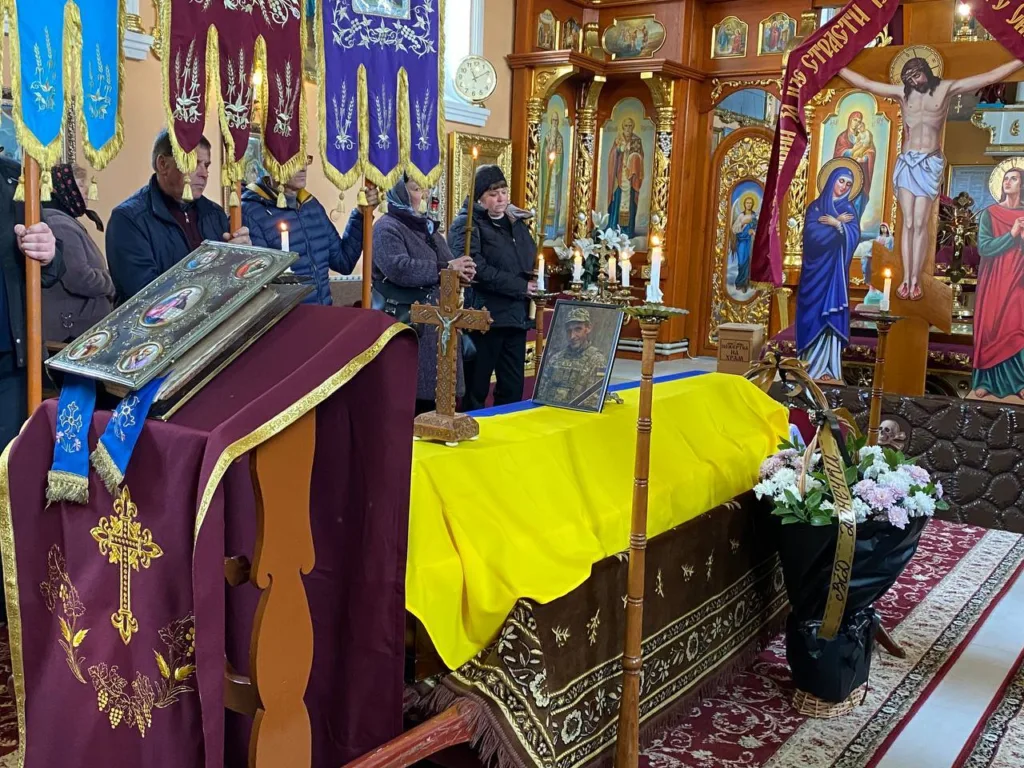 Похорон бійця у церкві, труна в прапорі України