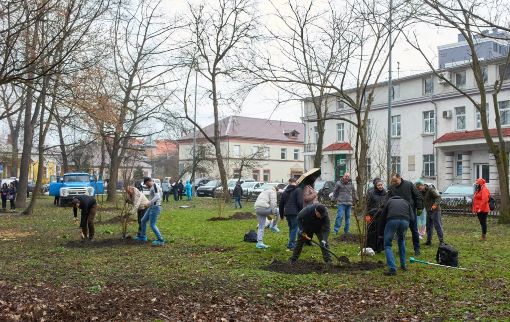 Люди садять дерева у міському парку