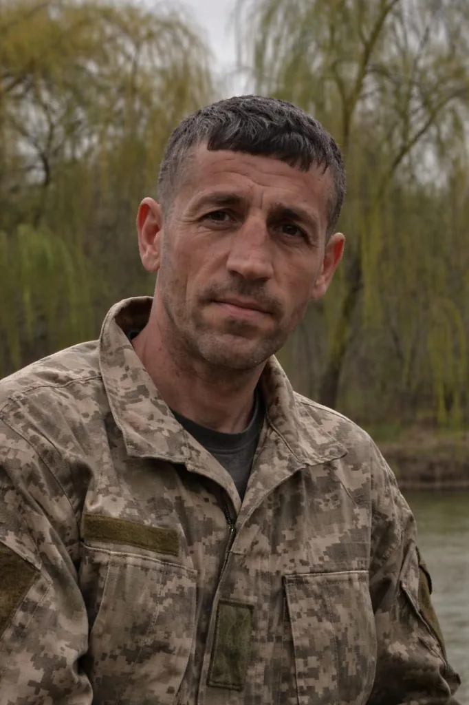 Військовий у камуфляжі біля річки