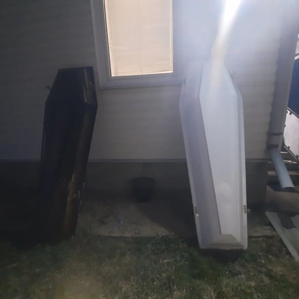 Дві труни стоять біля стіни будинку