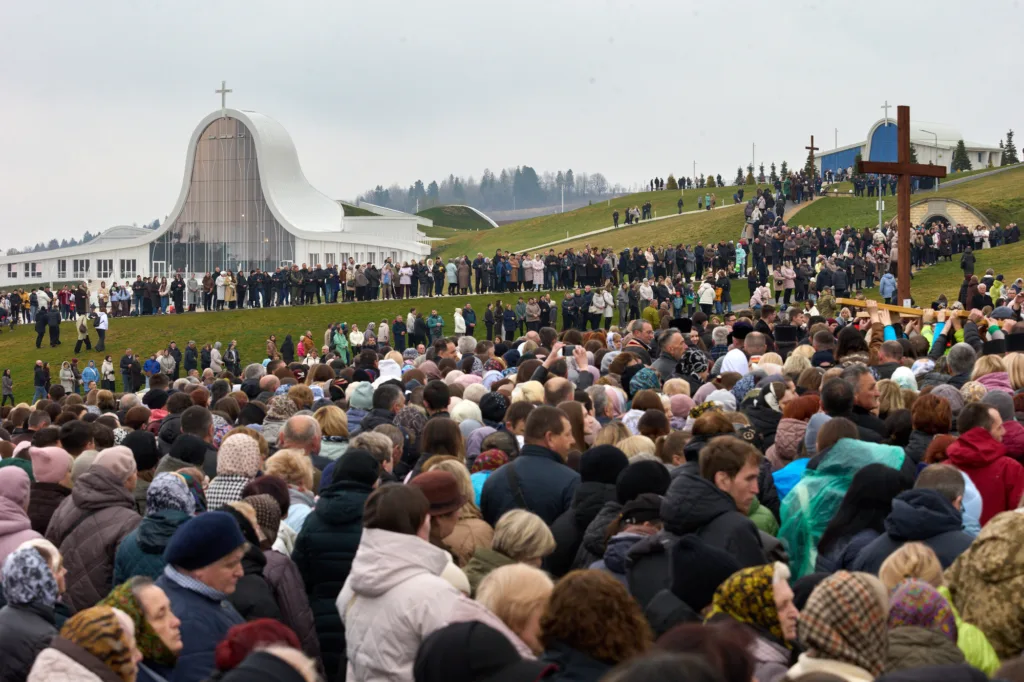 Натовп паломників біля сучасної церкви на пагорбі