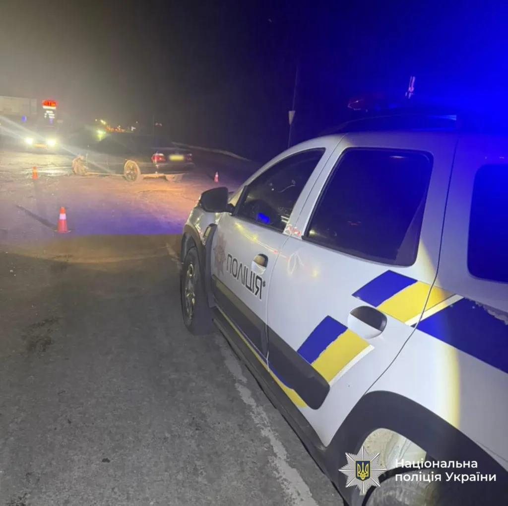 Поліцейська машина на місці дорожньої аварії вночі