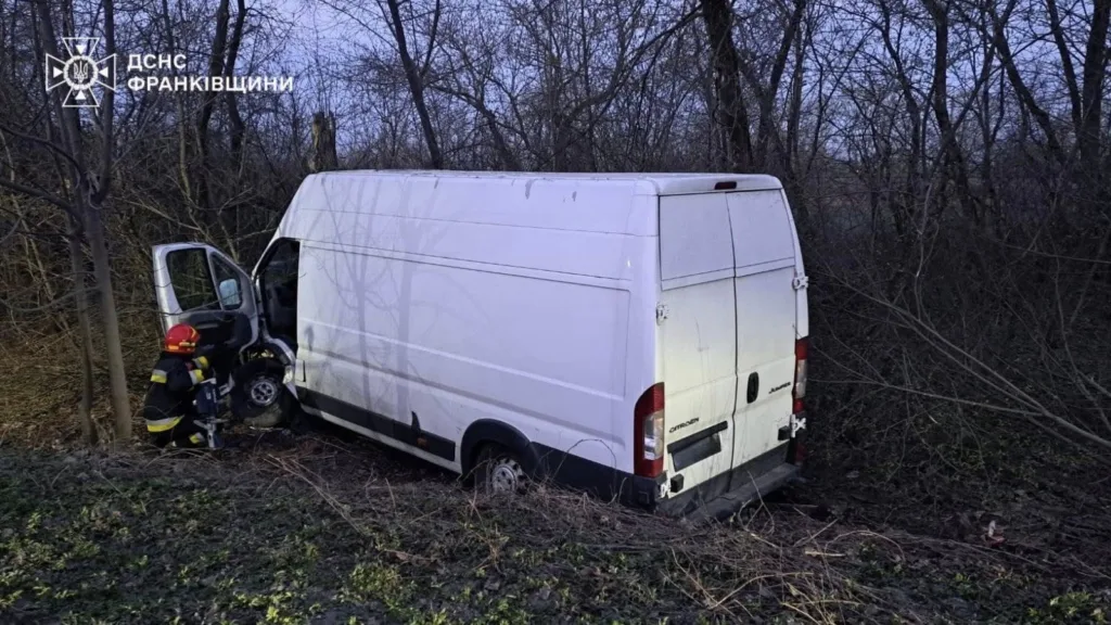 Пожежник біля фургона після ДТП у лісі