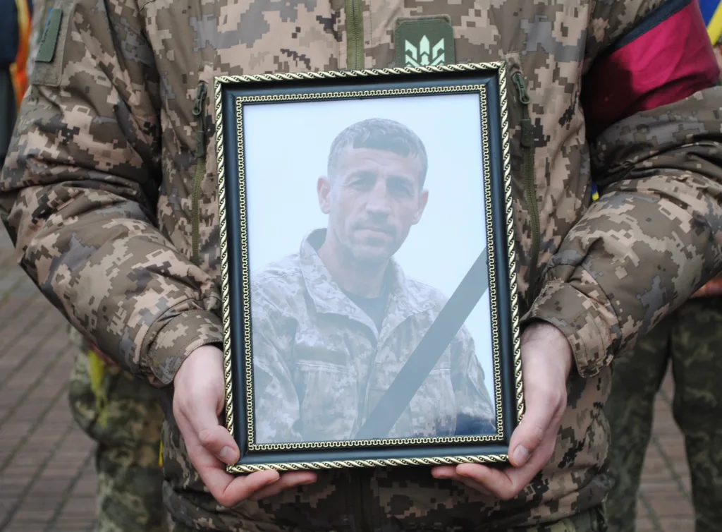 Військовий тримає фото загиблого солдата