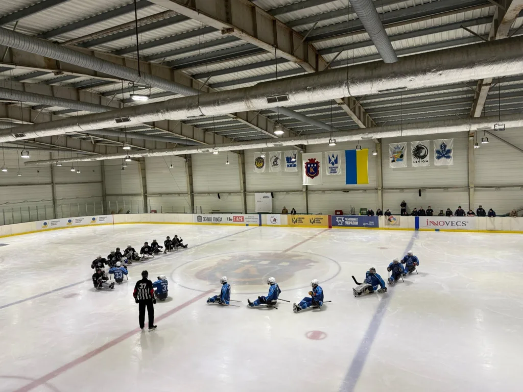 Гравці у хокеї на салазках на льодовій арені