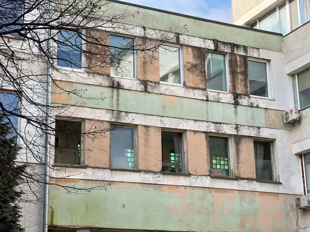 Стара будівля з облупленою фарбою і вікнами