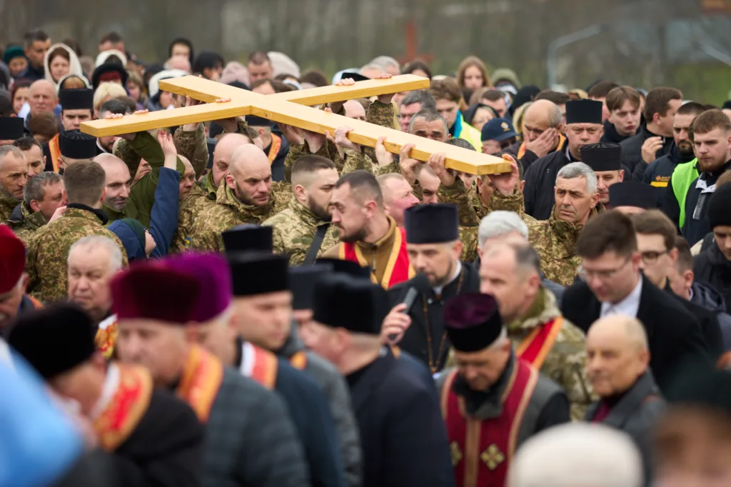 Військові та священники несуть великий дерев'яний хрест