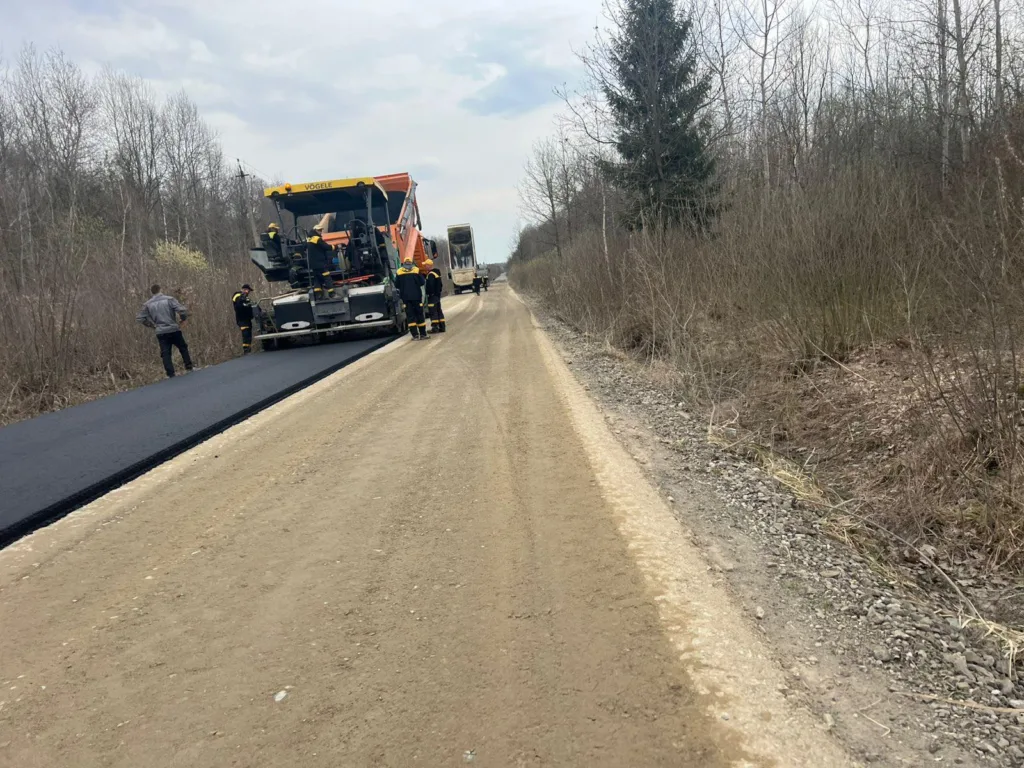 Робітники укладають асфальт на сільській дорозі