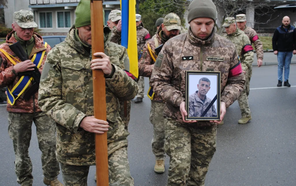 Військові несуть фото загиблого героя України