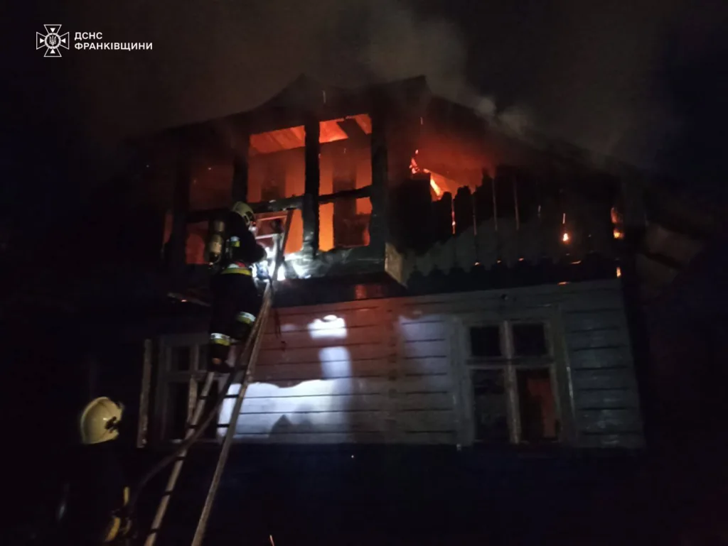 Пожежники гасять вогонь у дерев'яному будинку вночі