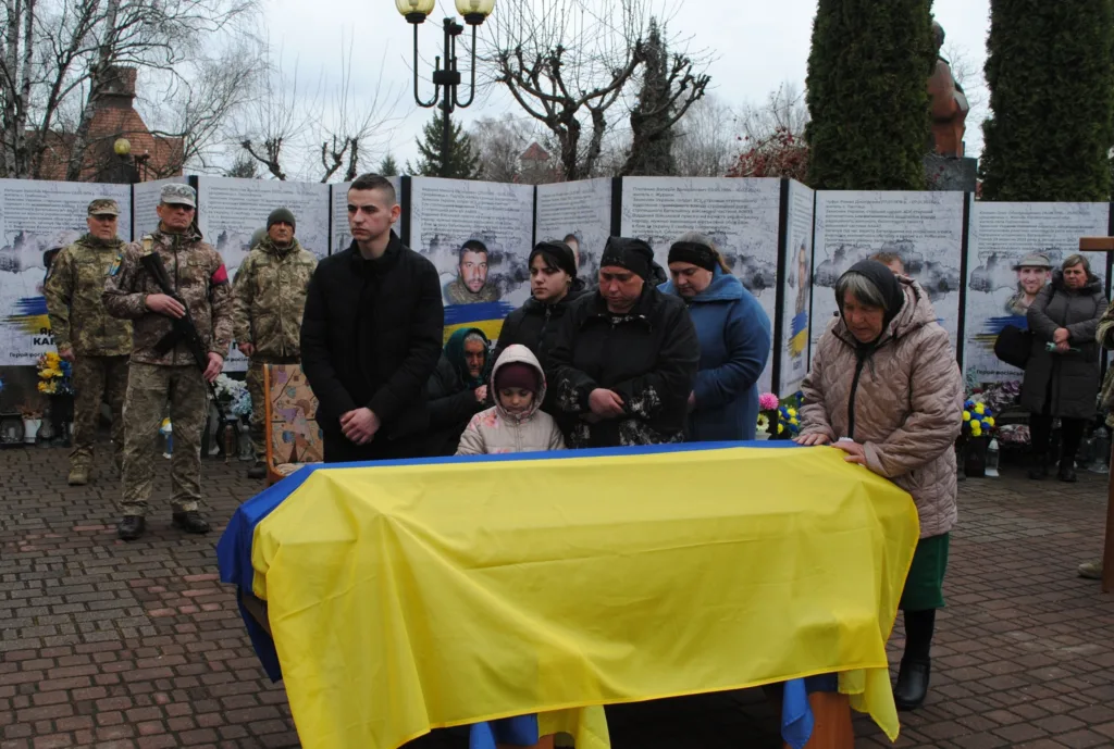 Прощання з загиблим військовим, труна в українському прапорі