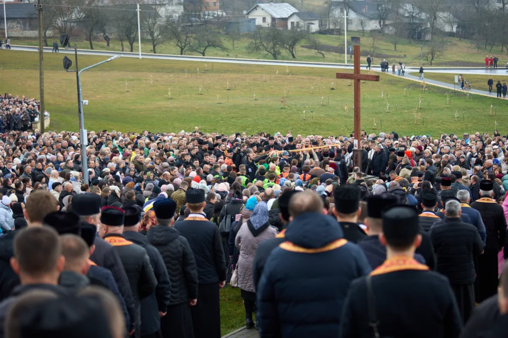 Натовп людей на релігійній церемонії біля хреста