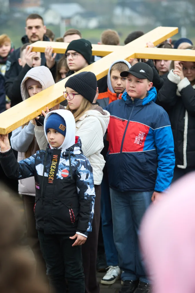 Діти несуть великий дерев'яний хрест під час процесії