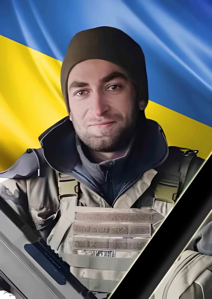 Український військовий перед прапором України