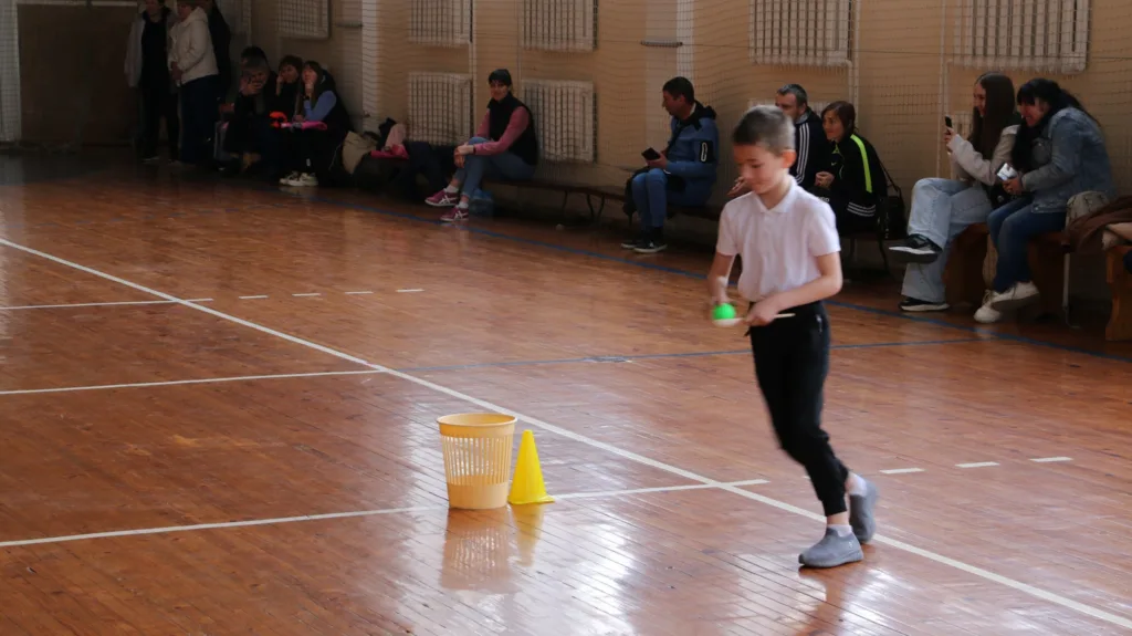 Дитина грає в естафету у спортивному залі