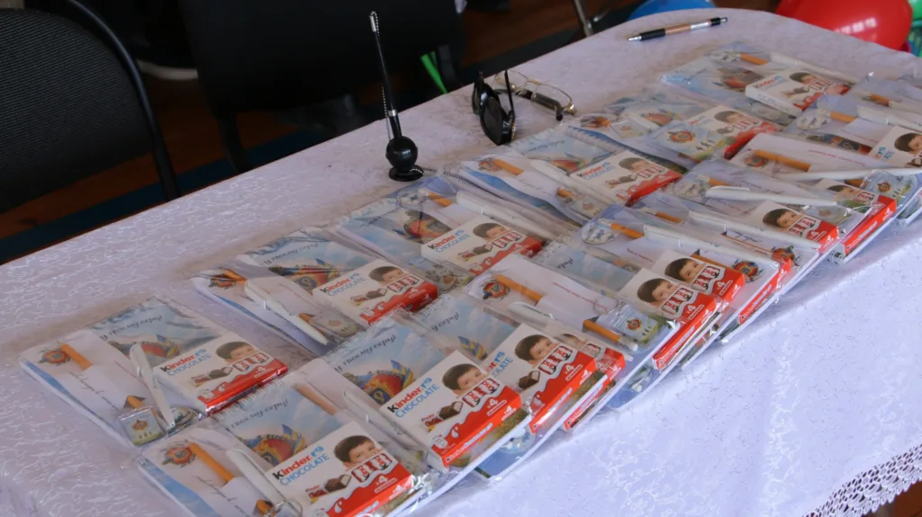 Подарункові набори з шоколадом і канцелярією на столі