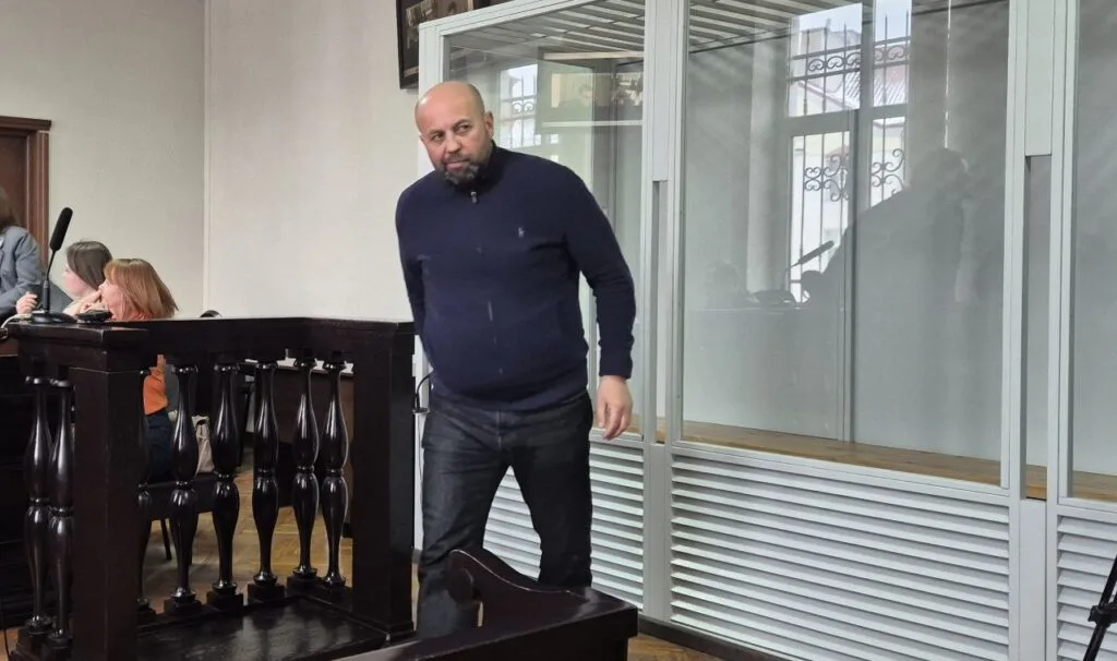 Чоловік стоїть у залі суду