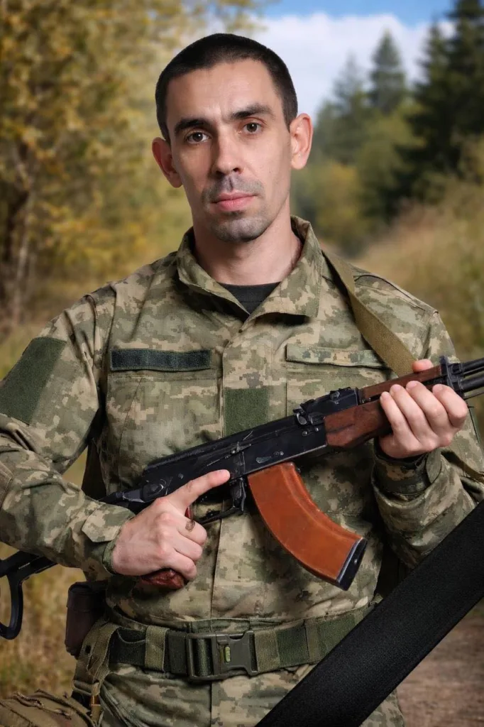 Військовий у камуфляжі з автоматом у лісі